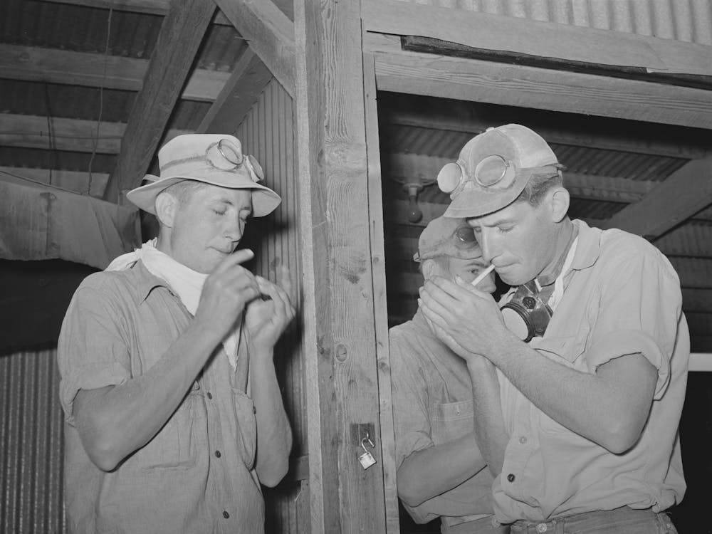 Workers On The Hay Gathering And Chopping Machine Taking Time Out For A Cigarette, The Goggles And Masks Are