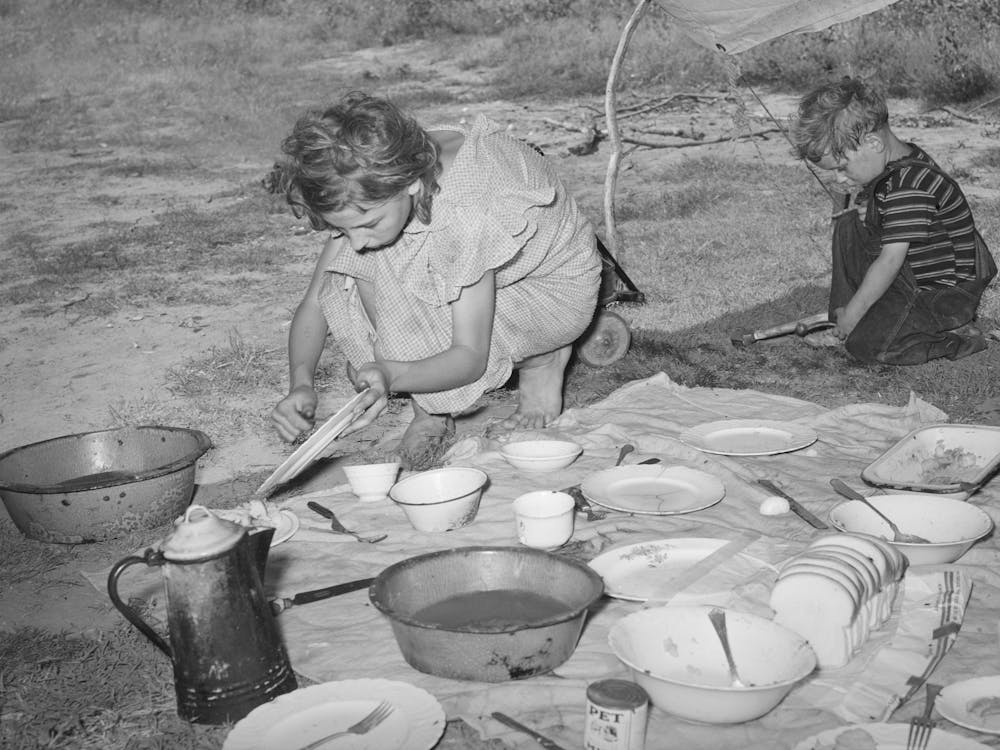Migrant Girl Scraping Plates After Noonday Meal Along The Highway Near Muskogee, Oklahoma, Muskogee