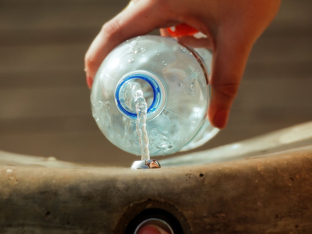 Female Hand Filling Plastic Water Bottle