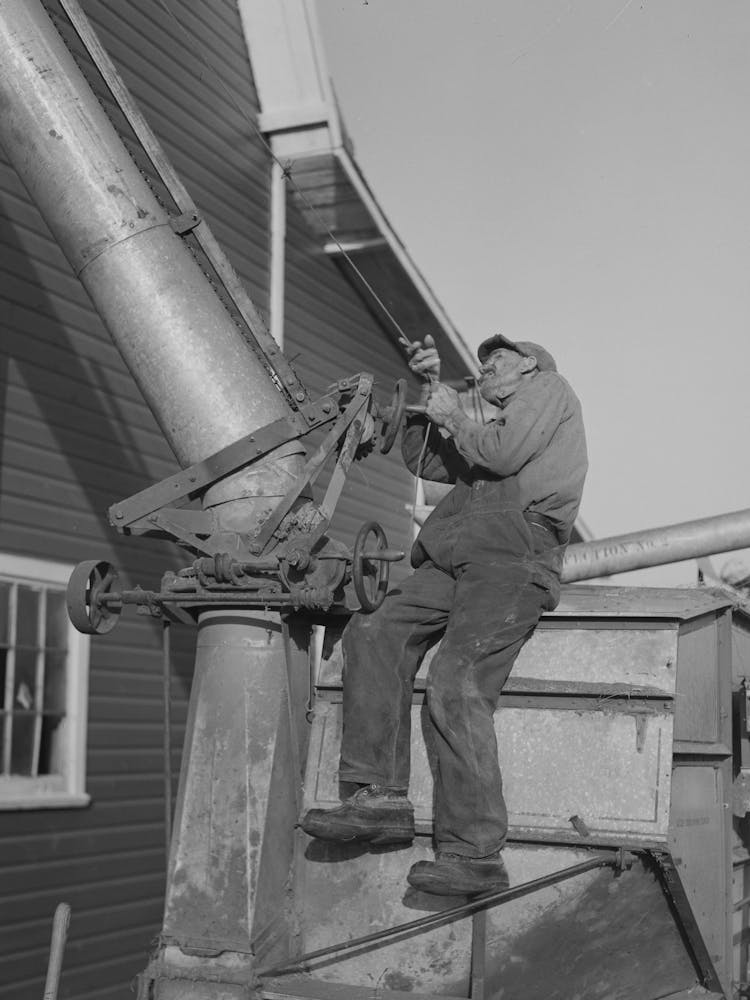 Farmer Working On Thresher Near Littlefork, Minnesota By Russell Lee