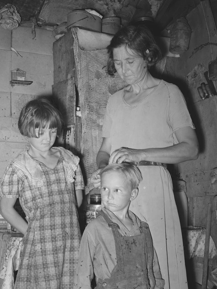 Woman In Shack Home In Community Camp, Oklahoma City, Oklahoma, Straightening Her Son S Hair Refer