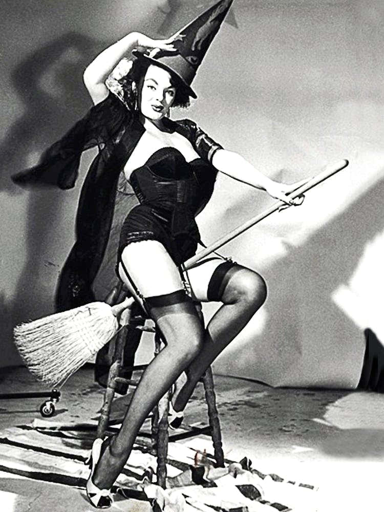 Young And Beautiful Witch Posing On A Broom In Studio