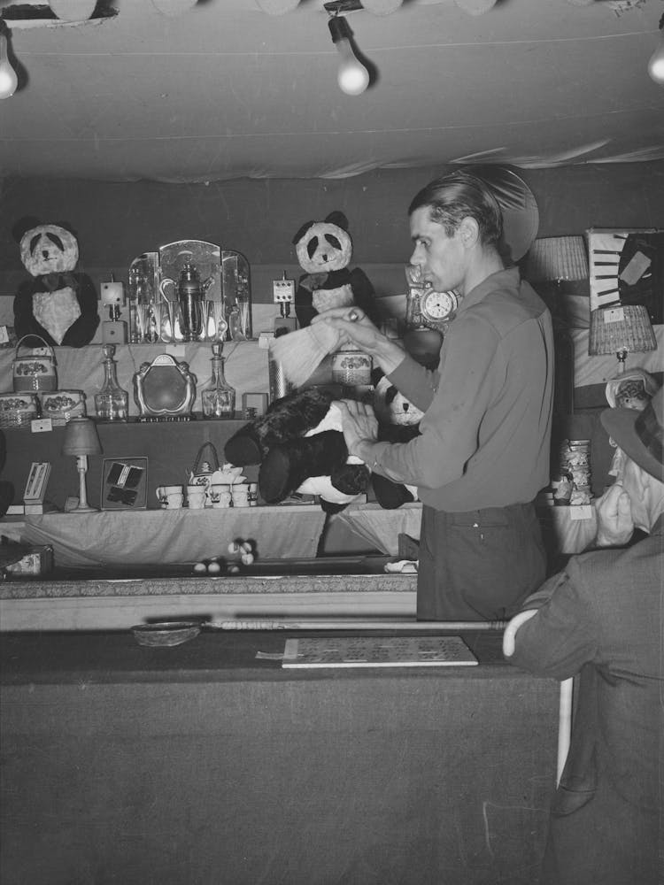 Concessionnaire Dusting One Of His Stock Prizes, A Teddybear, South Louisiana State Fair, Donaldsonville