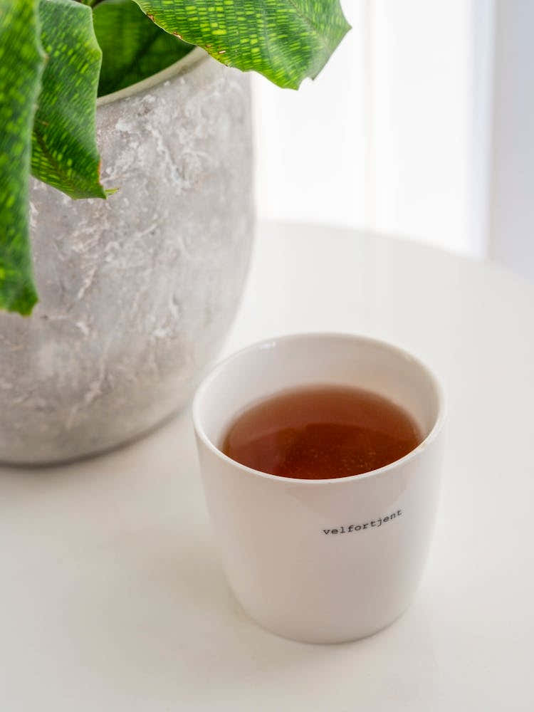 A scandinavian cup of tea with quote in Norway, Bergen in a white interior - winter hygge photography by Christa Stroo Photography