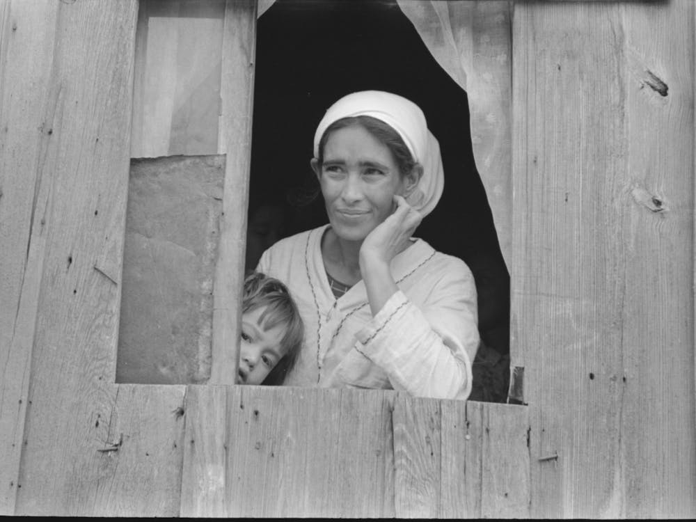 Mexican Woman And Son Looking Out Of Window Into Corral, San Antonio, Texas By Russell Lee