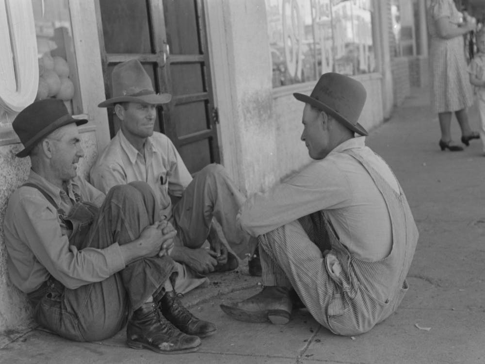 Farmers Sitting Against Wall And Squatting On Sidewalk, Spur, Texas By Russell Lee