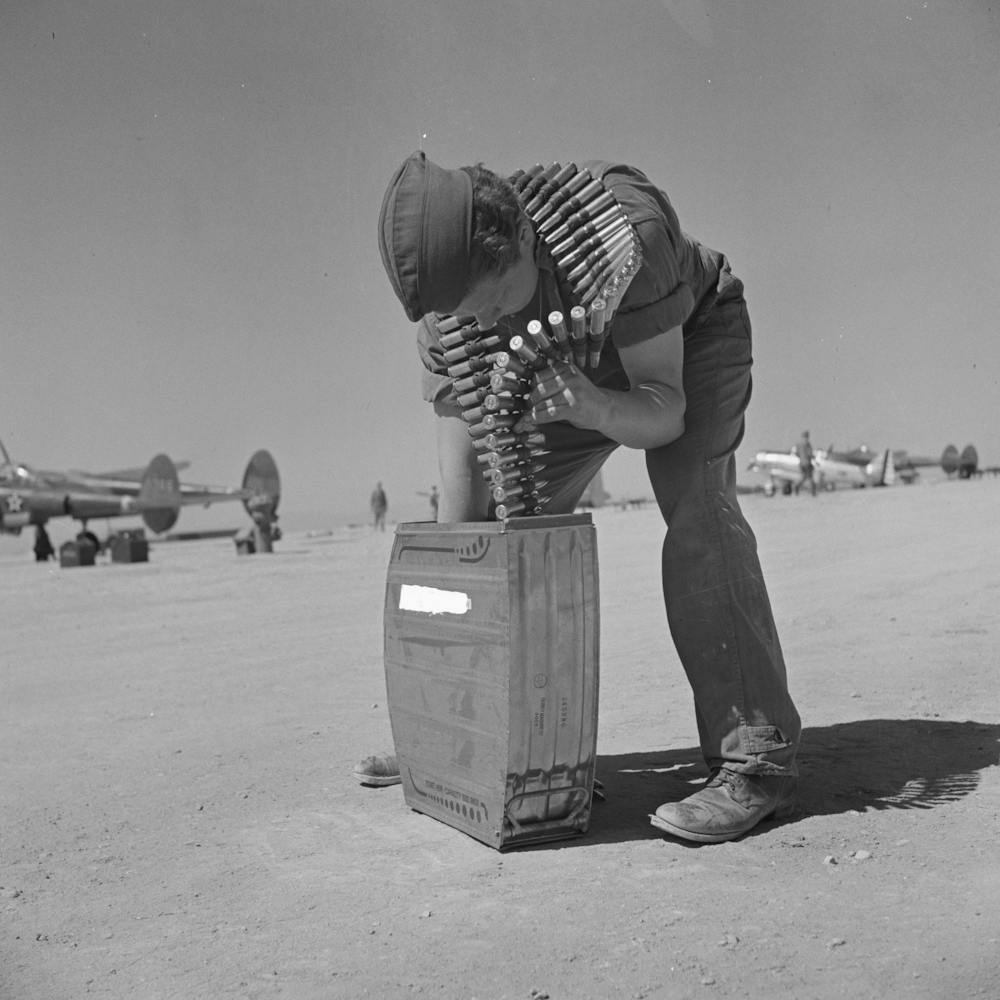 Waffenschmied legt Fünfzig-Kaliber-Maschinengewehrgeschosse in Magazin, Lake Muroc, California von Russell Lee
