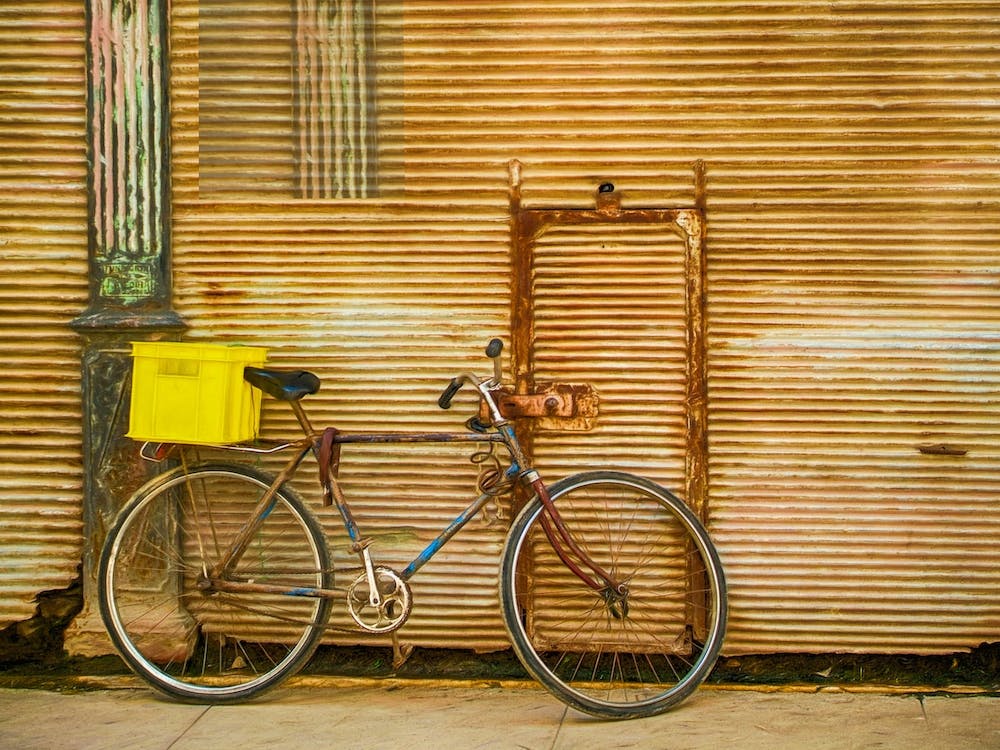 Bicycle Leaning Against Rusty Shutters
