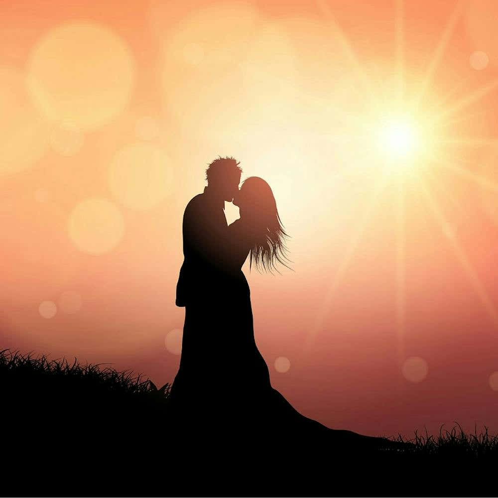 Silhouette Of Couple Kissing At Sunset
