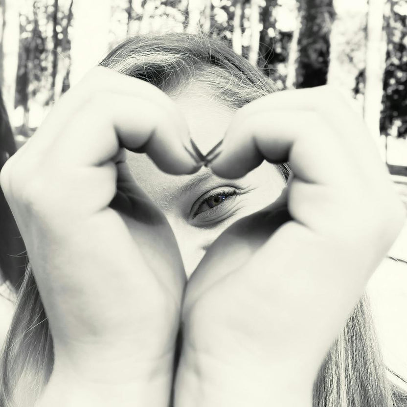 Woman Peeking Through A Heart Shape She Does With Her Hands