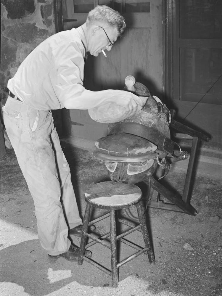 Druckausübung mittels Sandsäcken auf geklebtes Leder in einer Sattlerei, Alpine, Texas von Russ