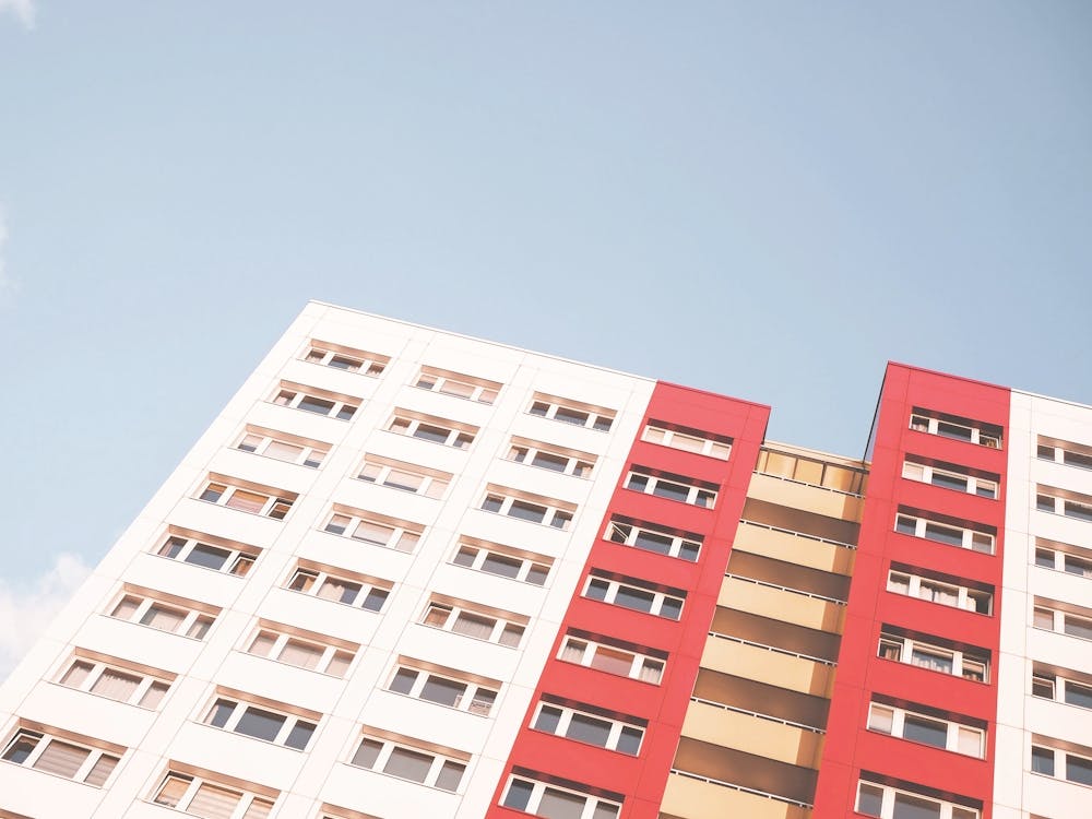 Berlin, Germany I Urban city architecture with geometric pastel building in red, white and yellow under spring light blue sky with minimalist Soviet Bauhaus style facade photography in perspective