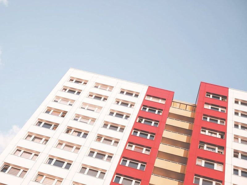 Berlin, Germany I Urban city architecture with geometric pastel building in red, white and yellow under spring light blue sky with minimalist Soviet Bauhaus style facade photography in perspective