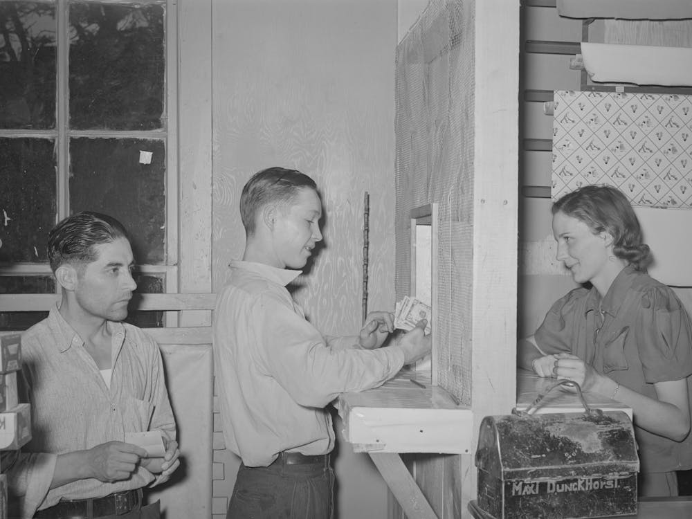 Young Miner Cashing Check At Commissary While Another Waits In Line For His Turn