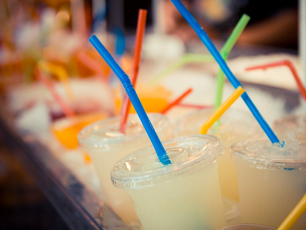 Selection Of Plastic Cups With Grapefruit Juice And Colored Straws
