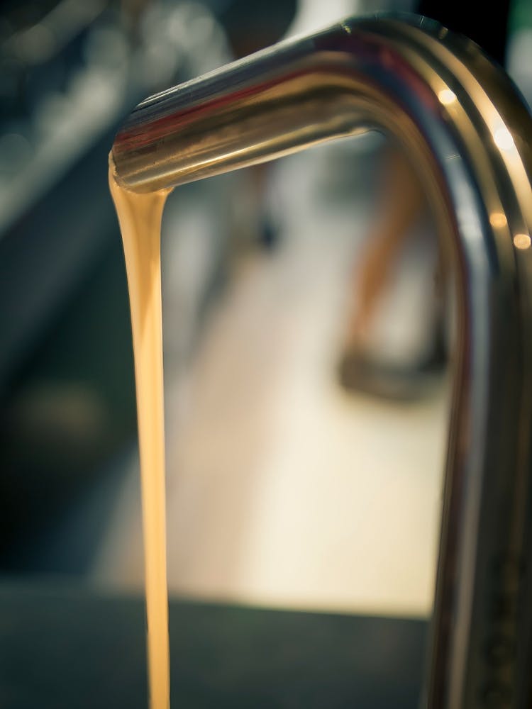 White Chocolate Flowing From A Faucet Metal