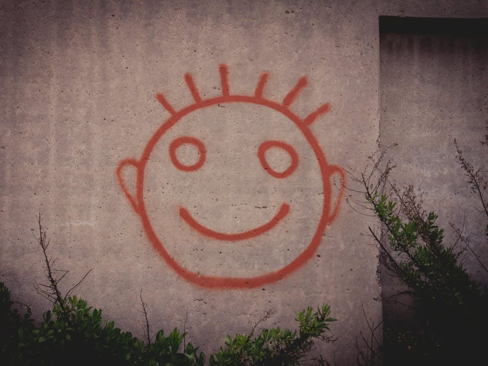 Graffiti-Gemälde Eines Roten Glücklichen Smiley-Gesichts Auf Einer Betonwand