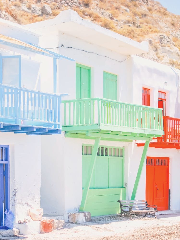 Milos, Greece I White architecture in the colorful fishing village of Klima facing Mediterranean Sea with its minimalist geometric composition in a summer blue green and red pastel aesthetic colors
