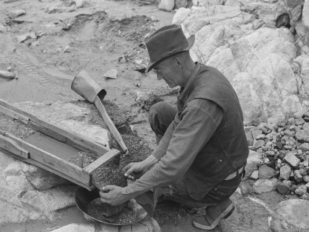 Prospector Removing Wire Screen From Bottom Of Sluice Box, This Screen Catches The Gold As The Water Washes