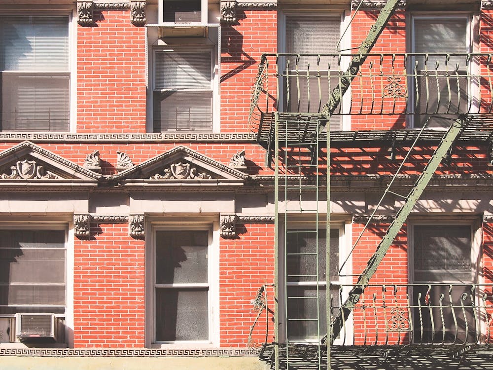 New York, USA I Little Italy building in red brick with fire escape and window for minimalist and geometric architecture photography for a Christmas and holidays atmosphere in winter interior decoration