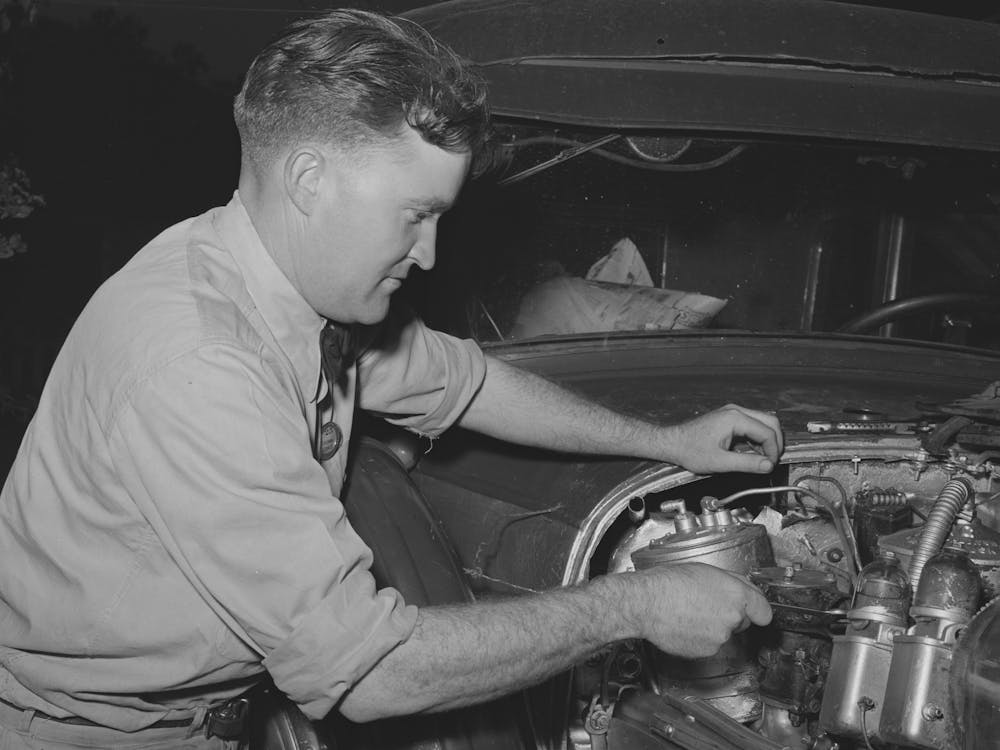 Consolidated Aircrafts Workman Working On His Self Assembled Automobile, This Is A Diesel Motor In This Car, San Diego