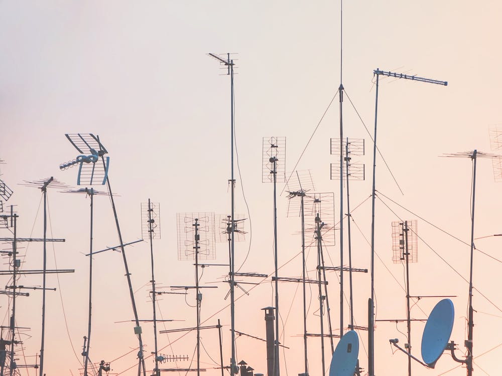 Rome, Italy I Graphic pattern of antennas over rooftops at sunset in a pink pastel summer sky light with minimalist and geometric cityscape photography evoking the poetic side of urban la dolce vita